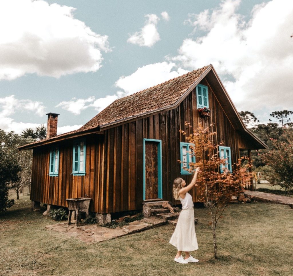 A woman enjoing her holidays in a charming rustic cabin made by wood during autumn time