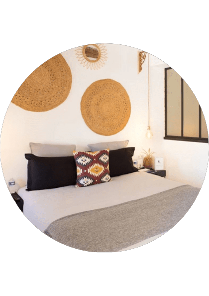A comfortable and large bedroom with patterned pillows and spiritual decoration